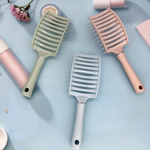 Three curved vented hairbrushes in pastel colors for volumizing and scalp massage