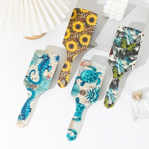 Artistic square hair brushes with sunflower and sea turtle patterns on white surface