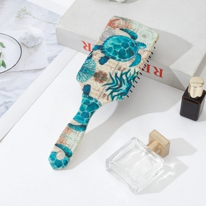 Detail of sea turtle print massage paddle hairbrush with hanging hole on a white desk