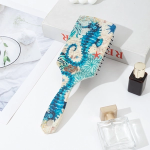 Detail of cushion hairbrush featuring a vintage seahorse pattern and ergonomic handle