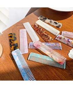 Detail view of colorful leopard and marble acetate hair combs on a wood background