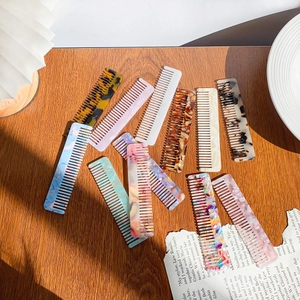 Chic leopard and marble print acetate hair combs arranged on a vintage wooden surface