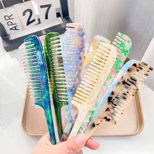 Set of 6 colorful acetate hair combs with marble and tortoiseshell patterns held in hand