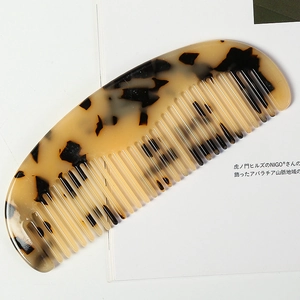 Detailed close-up of leopard pattern acetate hair comb on a minimalist magazine background