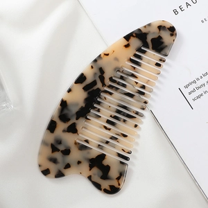 Detail of crescent acetate hair comb with leopard print on white silk background