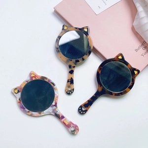 Cat-shaped acetate handheld mirrors with tortoiseshell patterns and glittery ear details