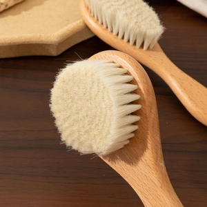Macro detail of natural soft wool bristles and smooth beech wood handle baby hair brush set