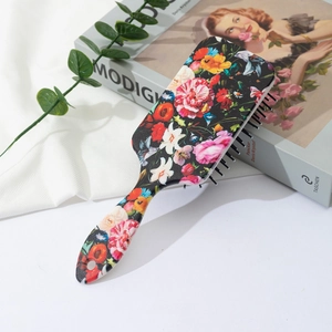 Detailed view of floral printed air cushion hairbrush with vibrant flower patterns
