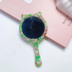 Cat-shaped acetate hand mirror with green tortoiseshell pattern and heart cutout detail
