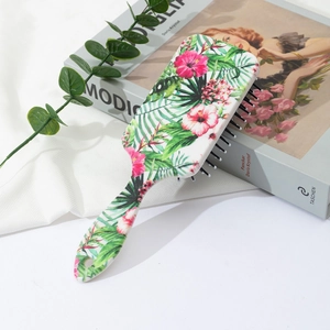 Detail of a tropical floral cushion hairbrush with pink hibiscus and palm leaves print