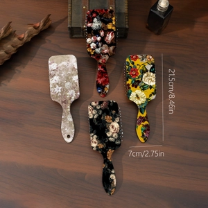 Detailed view of four vintage floral hair brushes with dimensions on a rustic wooden table