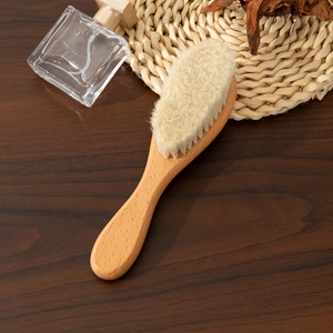 Detail of soft natural wool bristles and smooth beechwood handle for baby hair care