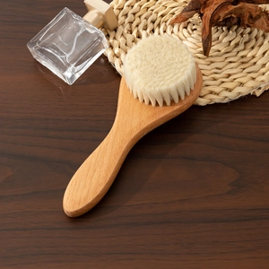Detail of high-density soft bristles and rounded beech wood handle for baby wool brush