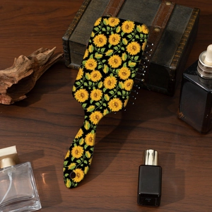 Portable air cushion hair brush with sunflower print design on premium wooden table