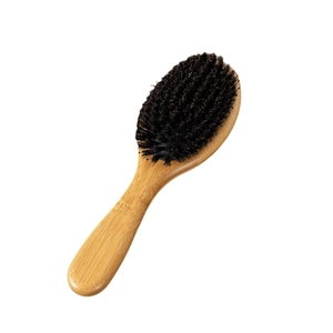 Oval boar bristle hair brush with natural bamboo handle for scalp massage on white background