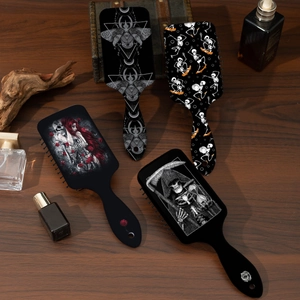 Detailansicht der Gothic-Haarbürsten mit Totenkopf- und Rosenmotiven auf Holzhintergrund