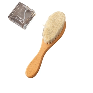 Natural beech wood baby hair brush with soft wool bristles on a clean white background