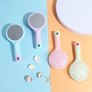 Pastel cushion hairbrush with mirror shown on a seaside themed decorative background
