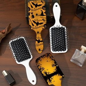 Halloween theme pumpkin hair brushes with orange prints on a dark rustic wooden background