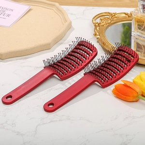 Two red vented hair brushes on a marble table with a French vintage mirror and tulips