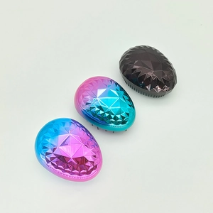 Detail view of portable egg-shaped detangling brushes with geometric 3D faceted design