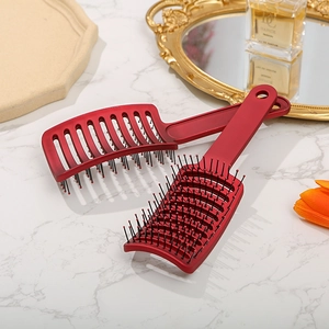 Detail of red hollow vented massage hair brushes on marble surface for styling
