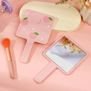 Pink handheld makeup mirror with cute peach pattern and ergonomic handle design