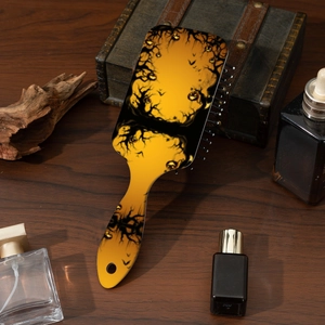 Detailed view of Halloween pumpkin hairbrush with bats on dark wood background