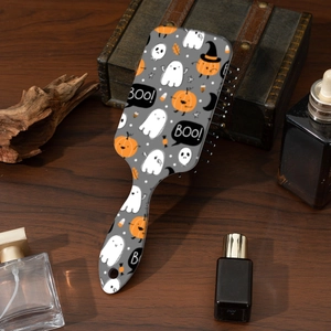 Detail of Halloween hair brush featuring cute pumpkin and ghost patterns on a wooden surface