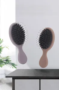 Macro detail of dual-color bristles and ergonomic handle on a mini cushion massage brush