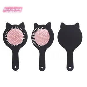 Detail view of cat-ear air cushion hairbrush in black and pink color scheme