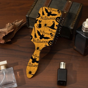 Detail of Halloween hairbrush with pumpkin patterns on vintage wood surface