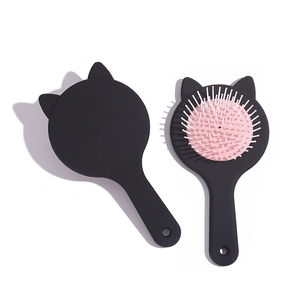 Cute cat-shaped hairbrush with pink air cushion and black frame on a clean white background