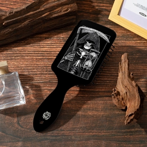 Detail eines gotischen Totenkopfmusters auf einer schwarzen Haarbürste mit Holz Hintergrund