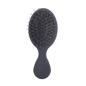 Mini portable matte air cushion hairbrush with boar bristles and nylon pins on white background