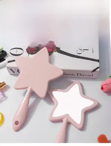 Detailed view of pink star-shaped handheld makeup mirror with sleek handle and hanging hole
