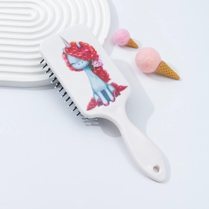 Detail of cartoon unicorn massage hairbrush with ergonomic white handle and air cushion