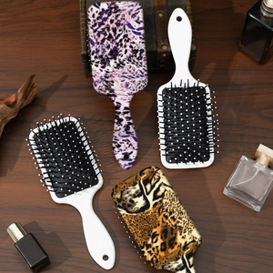 Haarbürsten-Set mit Leopardenmuster und Blumendesign auf Holzhintergrund