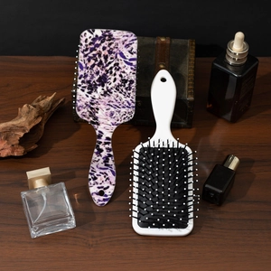 Haarbürsten mit Leopardenmuster und in Weiß auf Holztisch mit luxuriösen Accessoires