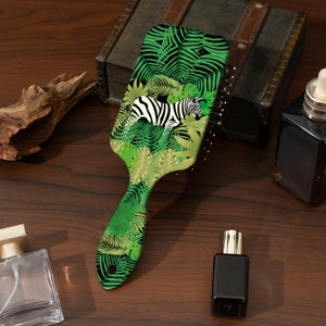 Detailansicht einer Massagebürste mit Zebra-Leopardenmuster auf Vintage-Holztisch