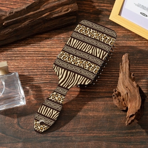 Bohemian air cushion hairbrush with leopard and zebra patterns on a dark wood background