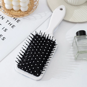 Detail of bohemian style paddle brush with anti-static bristles and massage tips
