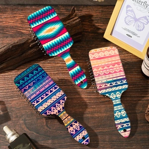 Bohemian pattern air cushion hairbrushes with colorful tribal prints on a wooden surface