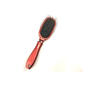Portable red metallic air cushion massage hairbrush with steel pins on white background