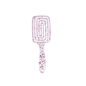 Macro detail of the spiral hollow design and purple glitter on a transparent hair brush