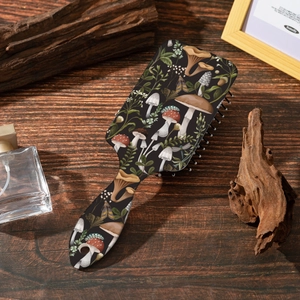 Gros plan d'une brosse à cheveux vintage à motifs de champignons sur une surface en bois