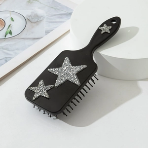 Vue détaillée de la brosse à cheveux noire avec décorations d'étoiles en strass