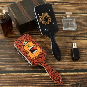Halloween air cushion hairbrushes with spider web and pumpkin patterns on wood table