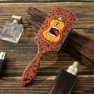 Detail of Halloween hairbrush featuring a 3D pumpkin embroidery and festive icons
