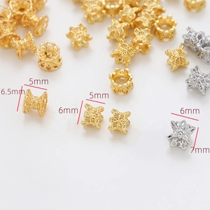 Détail macro de calottes de perles fleurs en métal creux en or 18K et argent pour bijoux